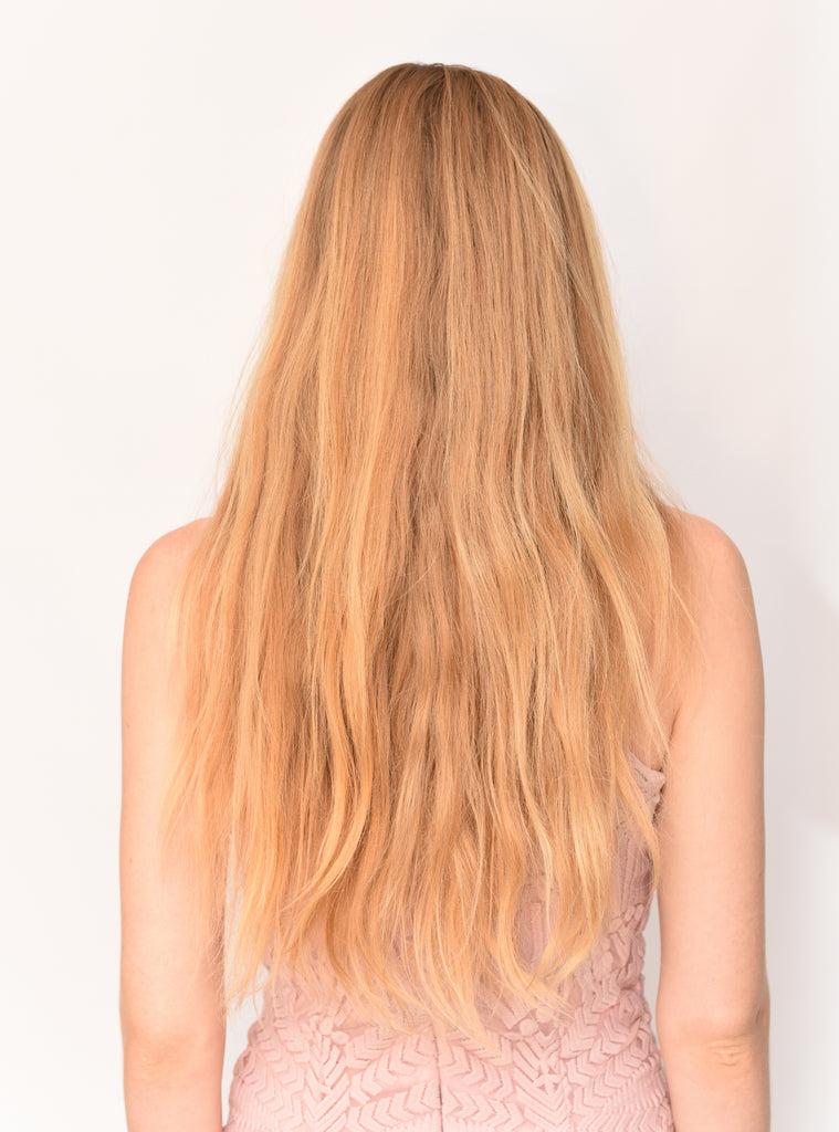 Back of model with coarse, dry un-styled loose blond hair before using hair heat protectant